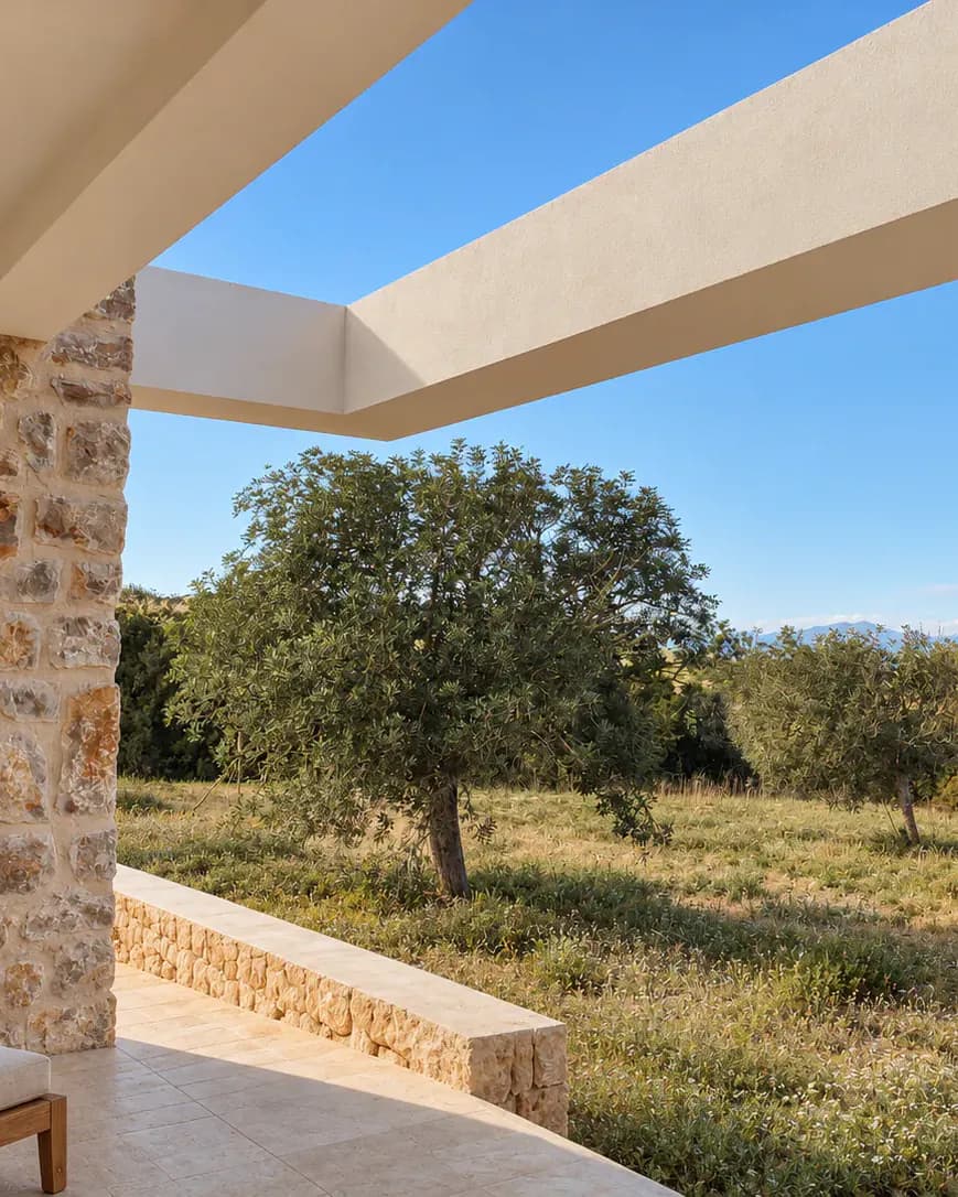 Pórtico blanco de la vivienda de Camí de l’Infern enmarcando un olivo y el campo